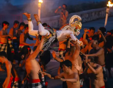 Dancers perform a traditional ritual with torches at night.
