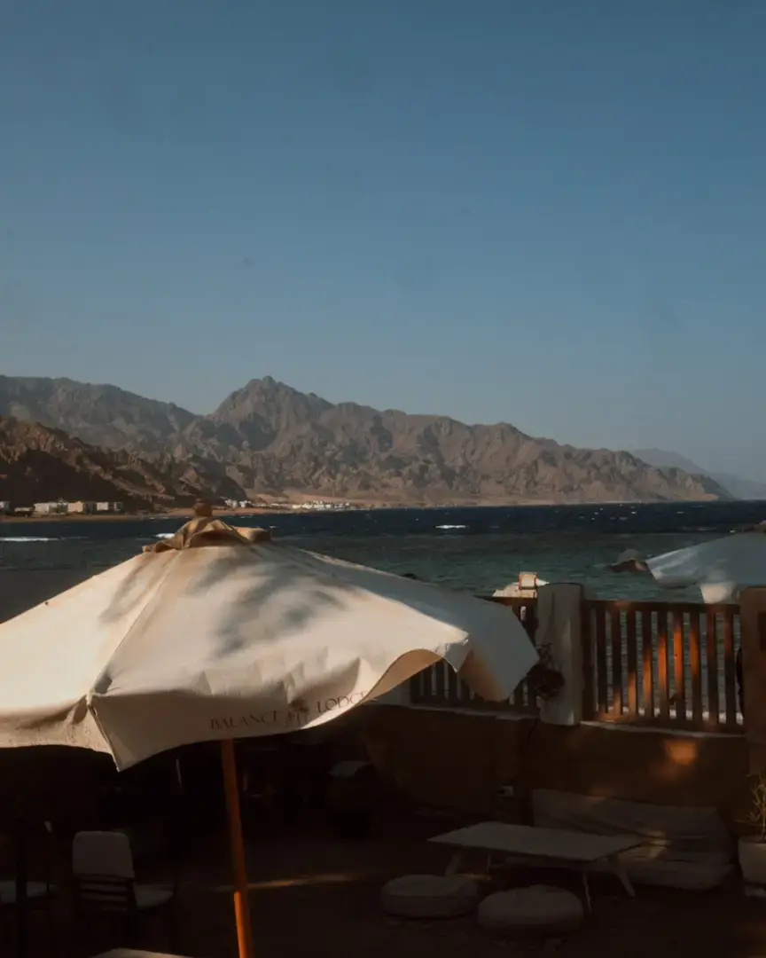 Beachside cafe with mountains and ocean view.