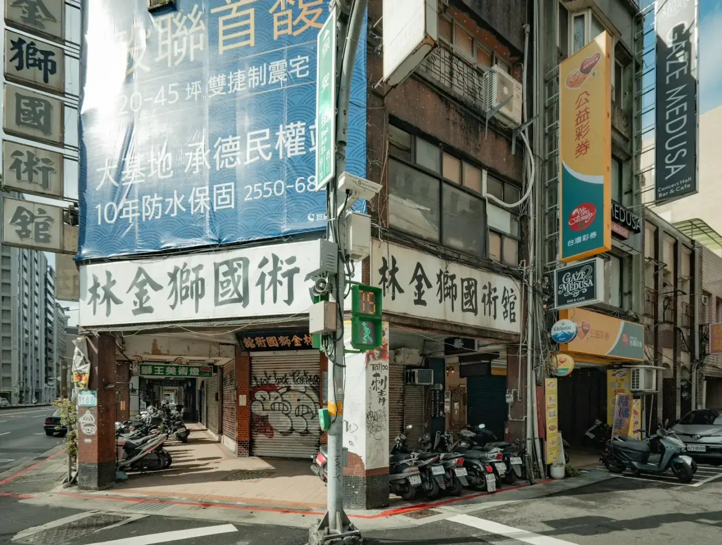 Street view of buildings with signs and parked motorcycles.
