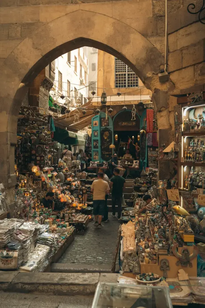 Photo by Kuan L Bustling market stalls under an ancient stone archway.