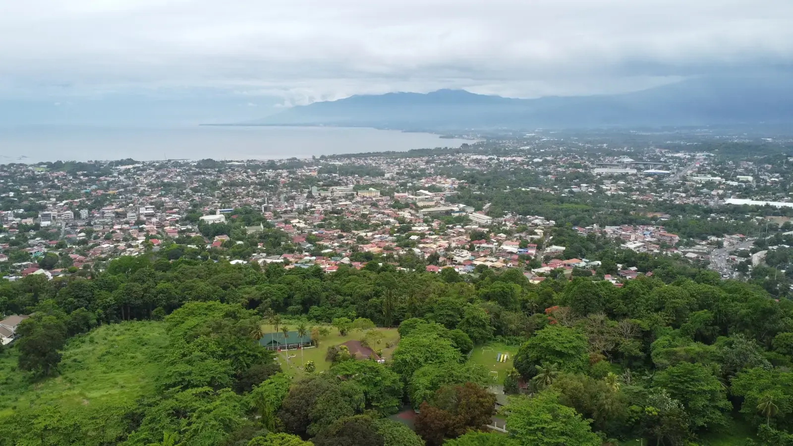an aerial view of a city with a lake in the background