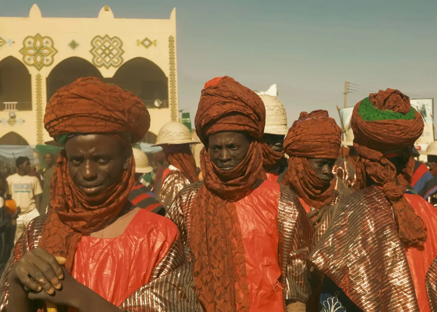 African men wearing traditional red robes and turbans.