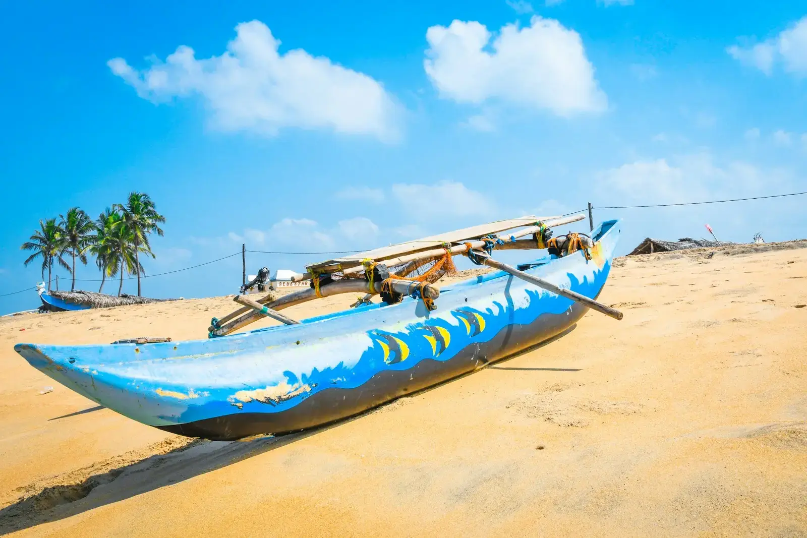 a blue boat sitting on top of a sandy beach