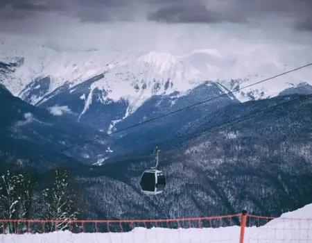 Scenic view of snow-capped mountains with a cable car in a winter ski resort setting.
