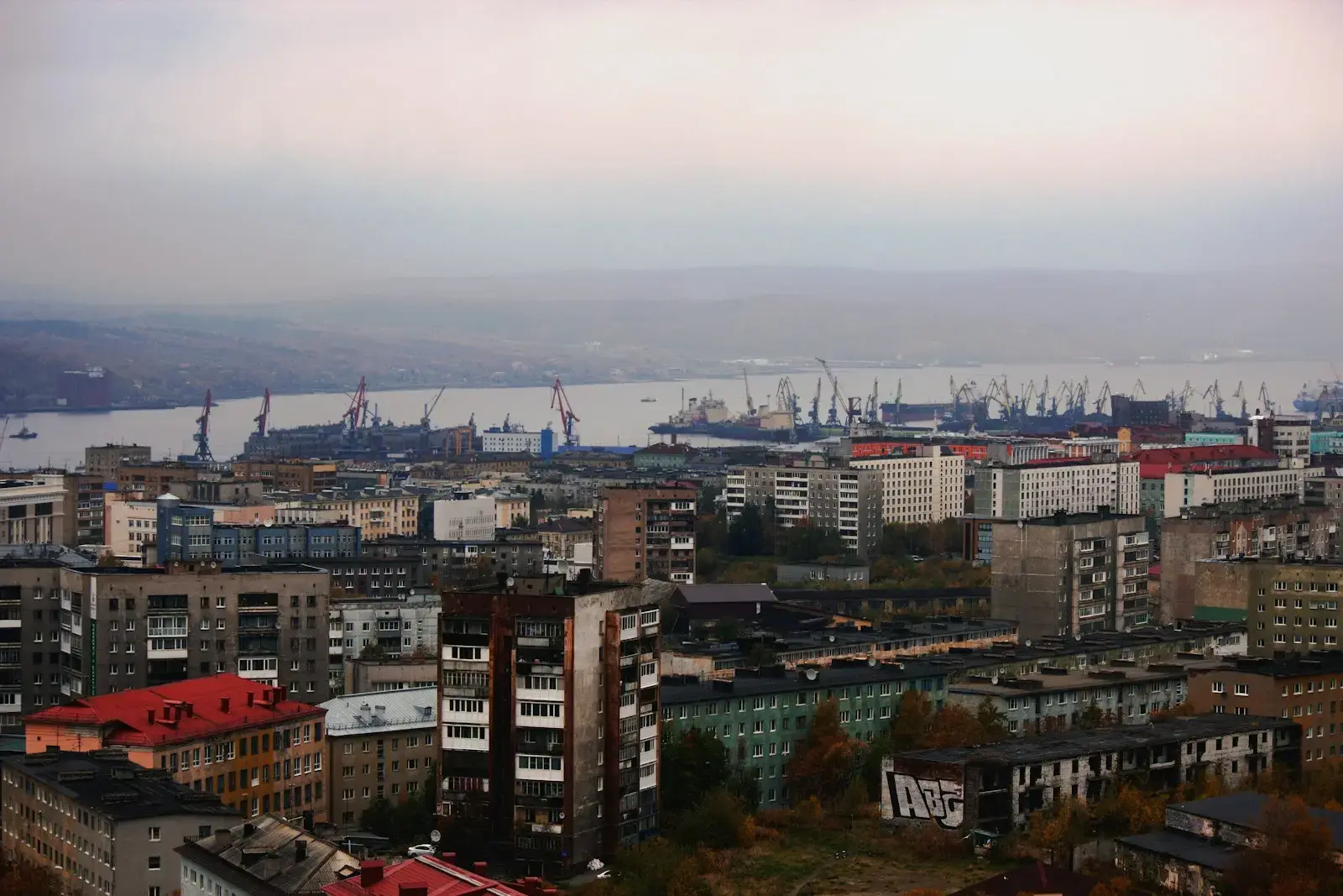 City skyline with a busy harbor and cranes