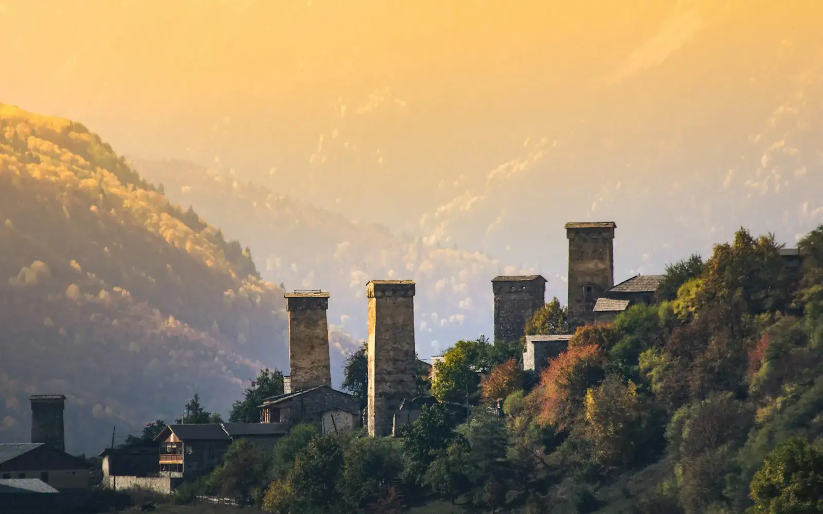 Photo by Marek Piwnicki a row of towers on a hillside with a mountain in the background
