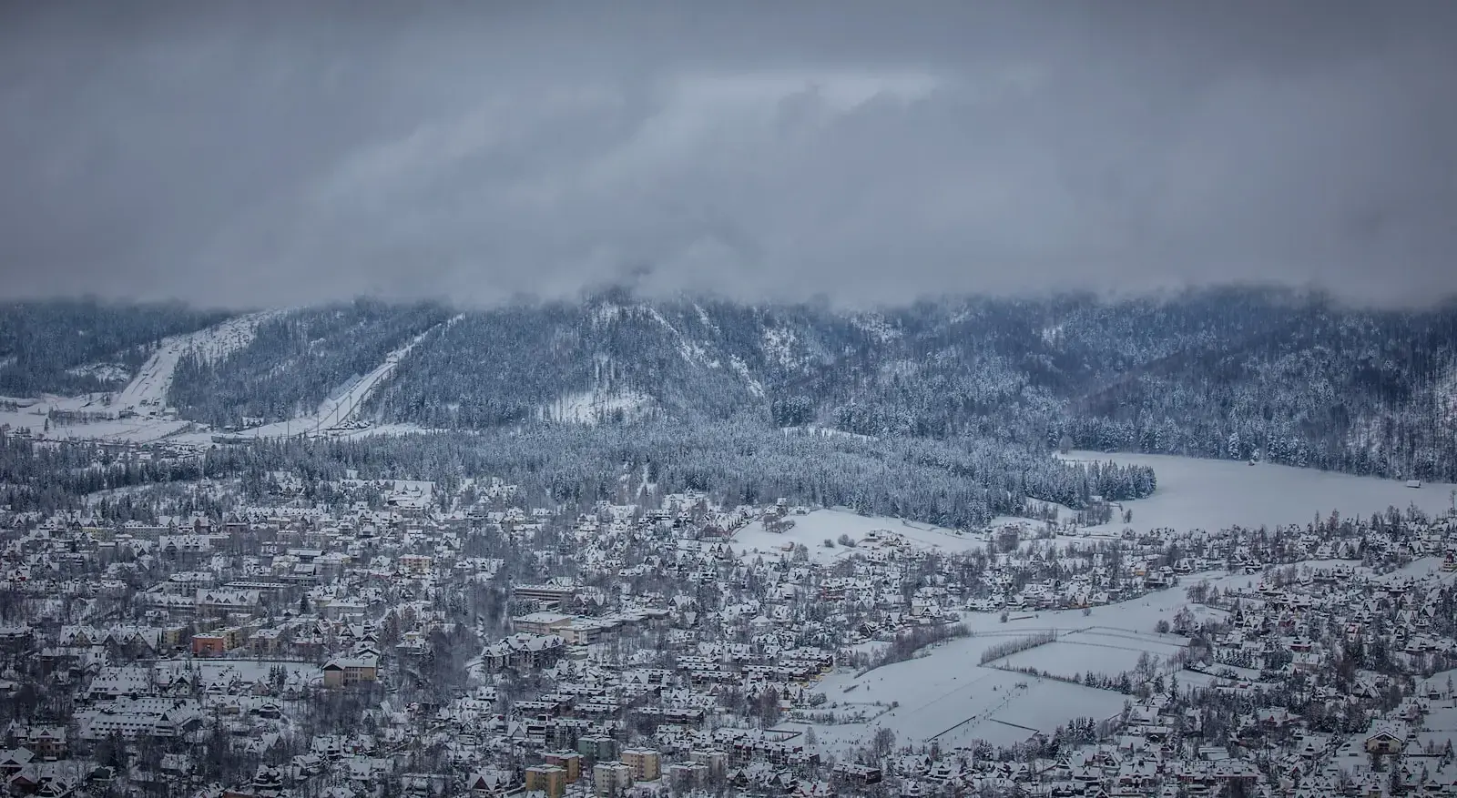 Photo by Gregory Atkats a snow covered mountain with a city below