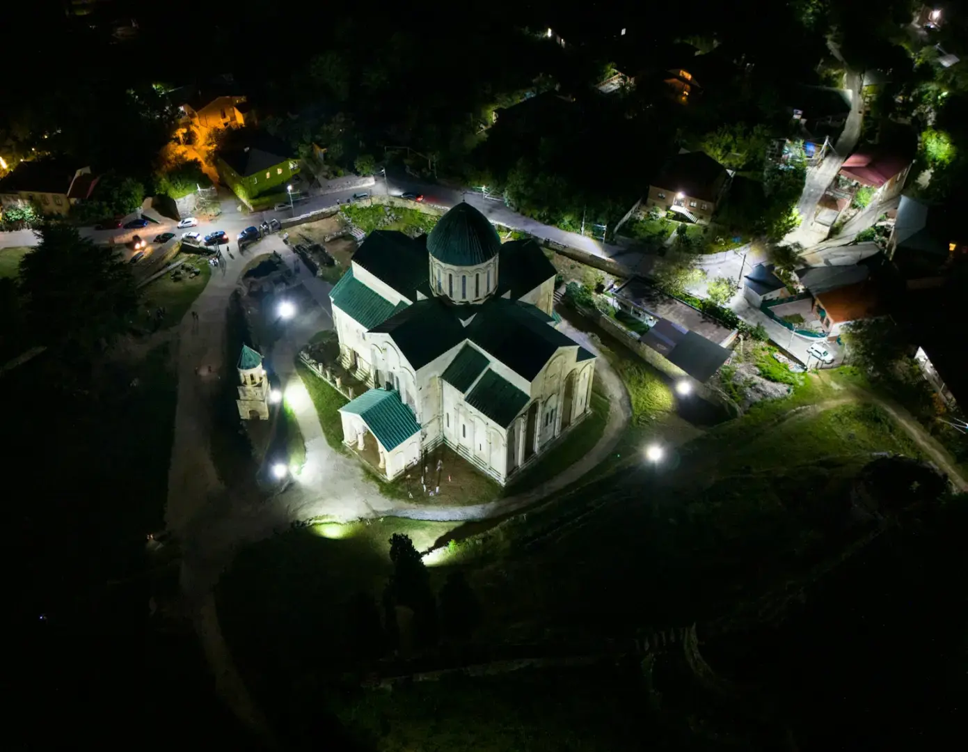An aerial view of a lit church at night.