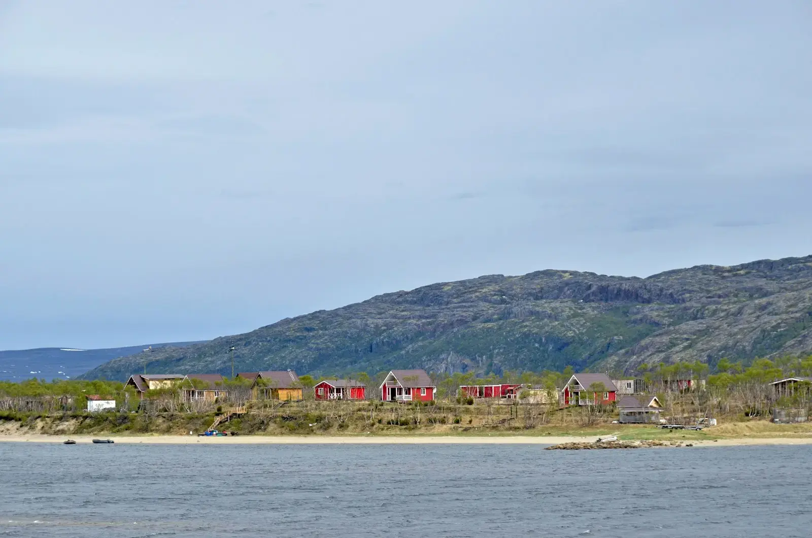 a body of water with houses on a hill in the background
