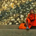 boy sitting on stairs and holding gold smartphone