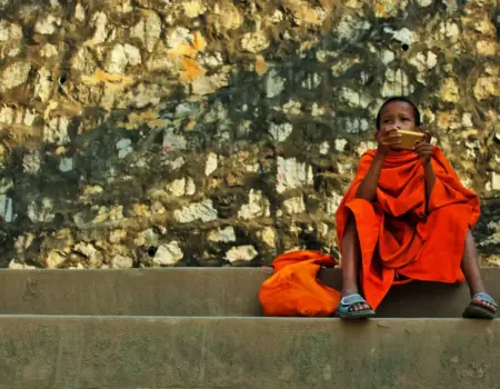 boy sitting on stairs and holding gold smartphone