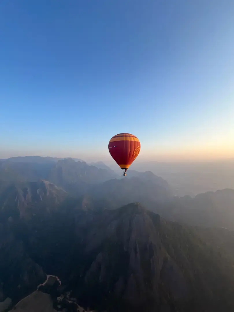 A hot air balloon flying over a mountain range