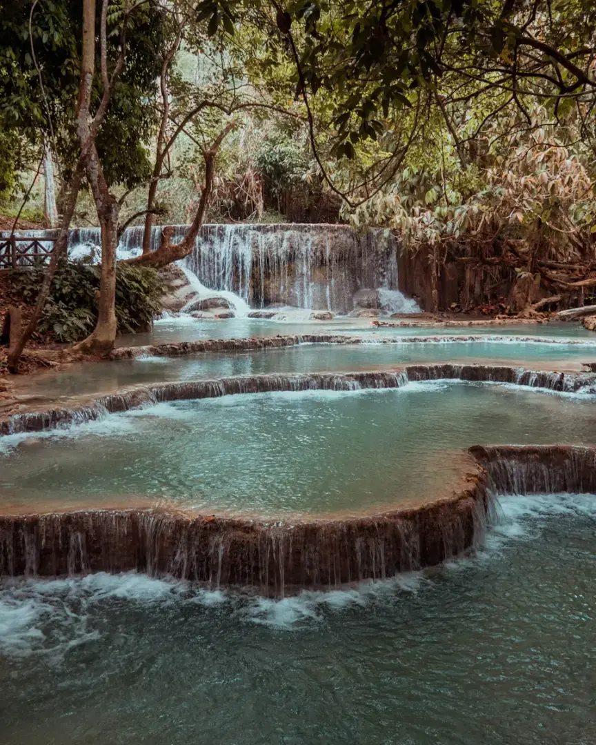 Photo by Giuliano Gabella water falls in the middle of trees