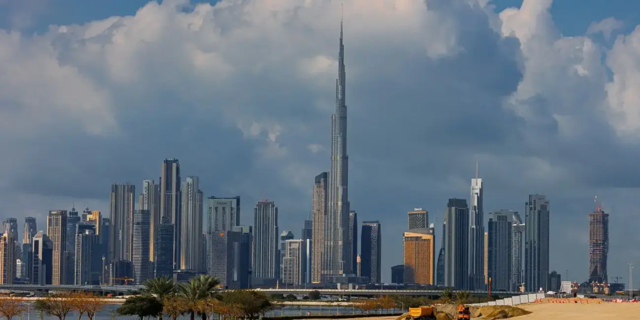 A breathtaking view of the Burj Khalifa towering over the stunning skyline of Dubai under dramatic clouds.