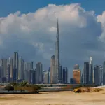 A breathtaking view of the Burj Khalifa towering over the stunning skyline of Dubai under dramatic clouds.