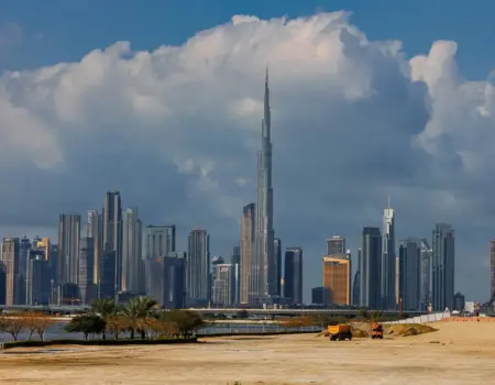 A breathtaking view of the Burj Khalifa towering over the stunning skyline of Dubai under dramatic clouds.