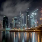 Stunning night view of Dubai's illuminated skyline featuring the iconic Burj Khalifa and waterfront reflections.