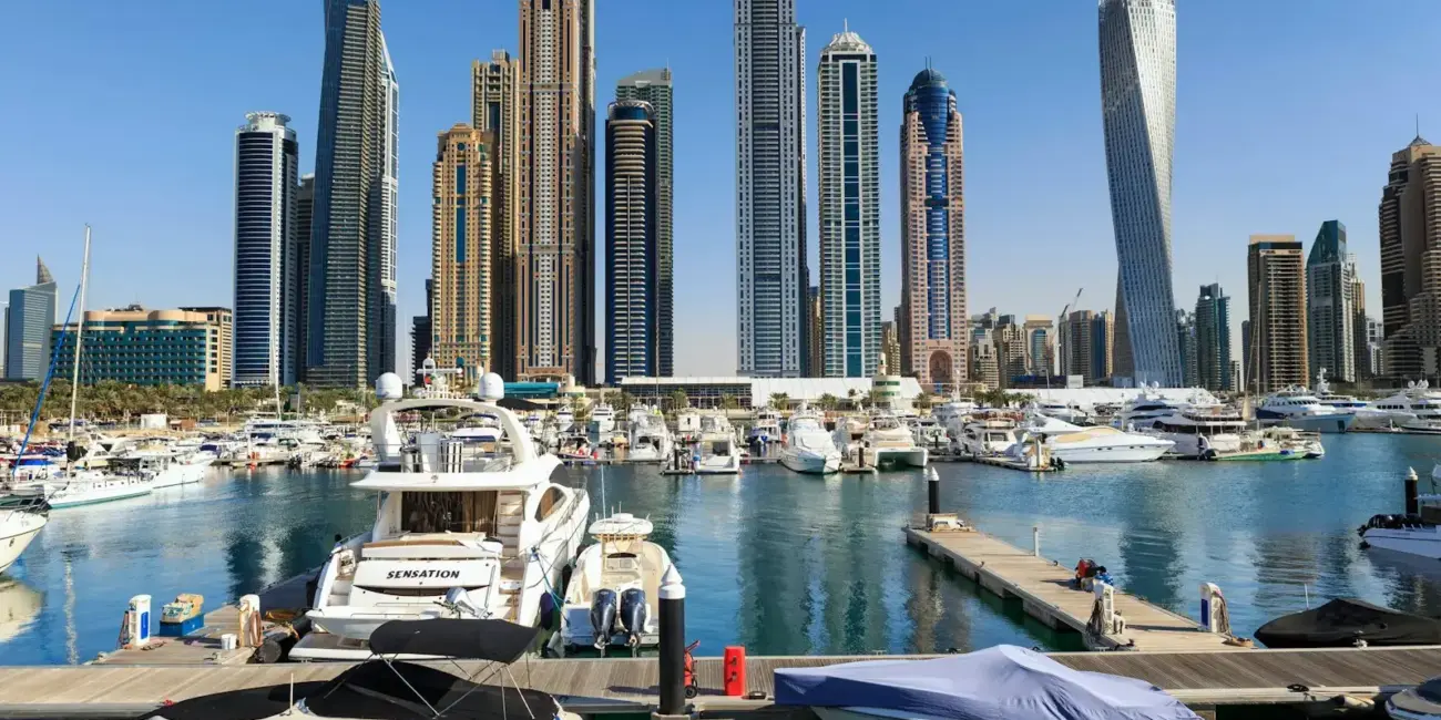 Boats and skyscrapers line a beautiful harbor.