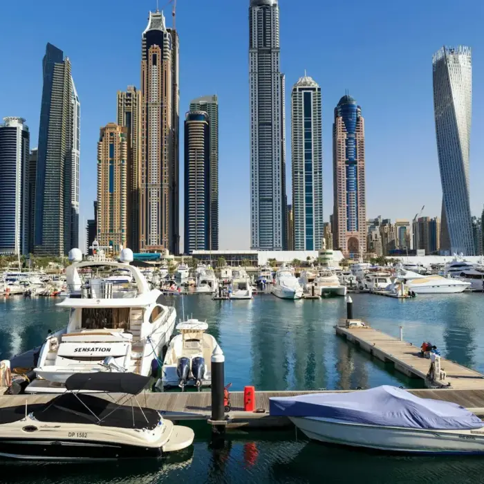 Boats and skyscrapers line a beautiful harbor.
