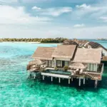 a couple of houses sitting on top of a body of water