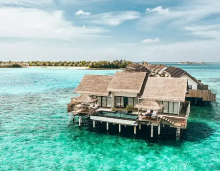 a couple of houses sitting on top of a body of water