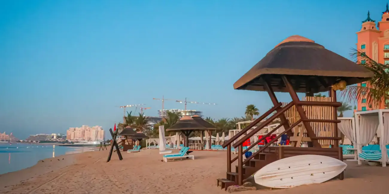 Beach with lifeguard station and resort in the background.