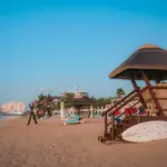 Beach with lifeguard station and resort in the background.