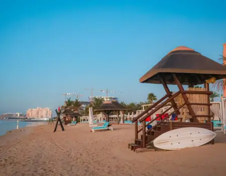 Beach with lifeguard station and resort in the background.