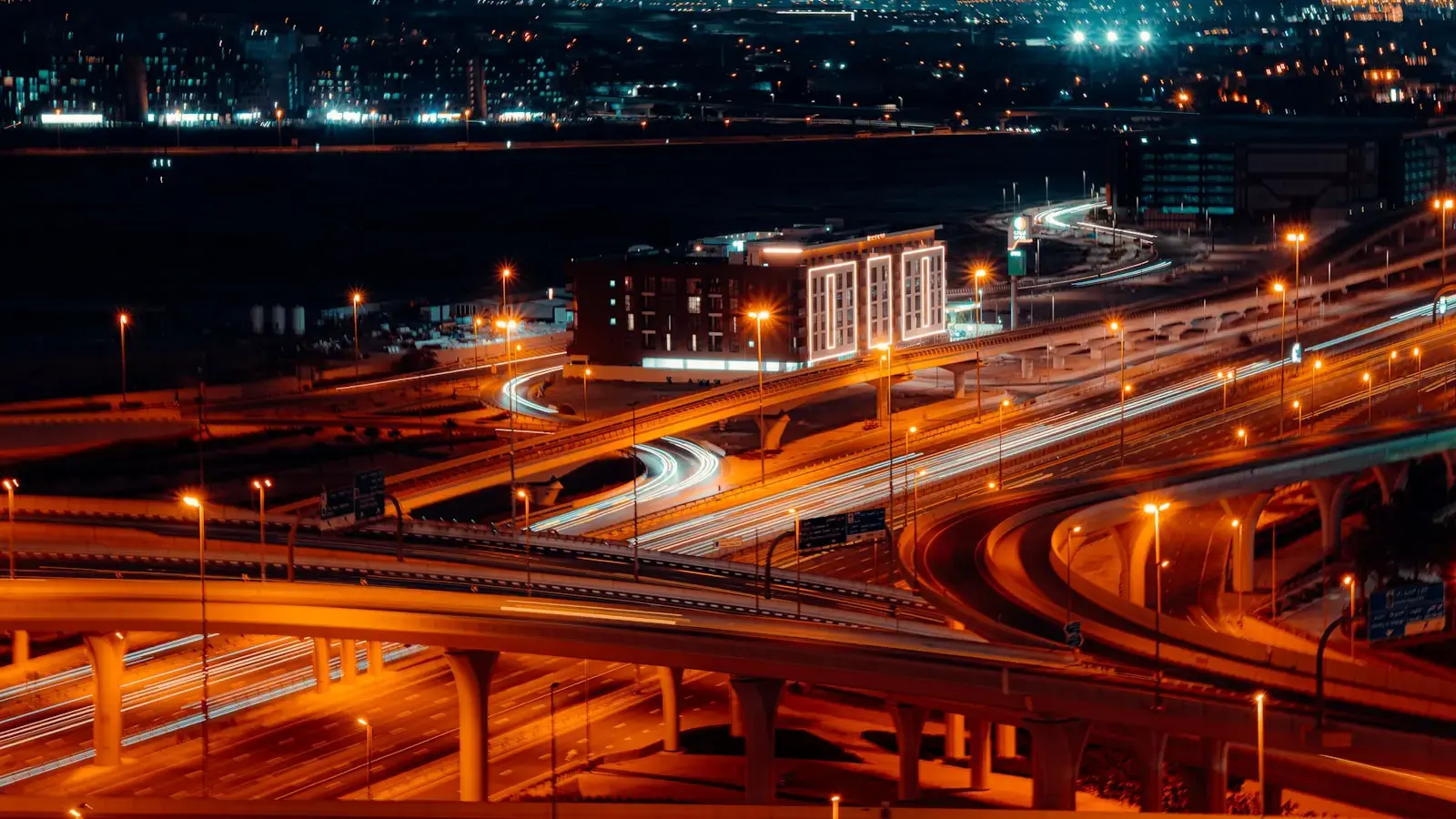 Photo by Dawid Tkocz Busy highway interchange with light trails at night.