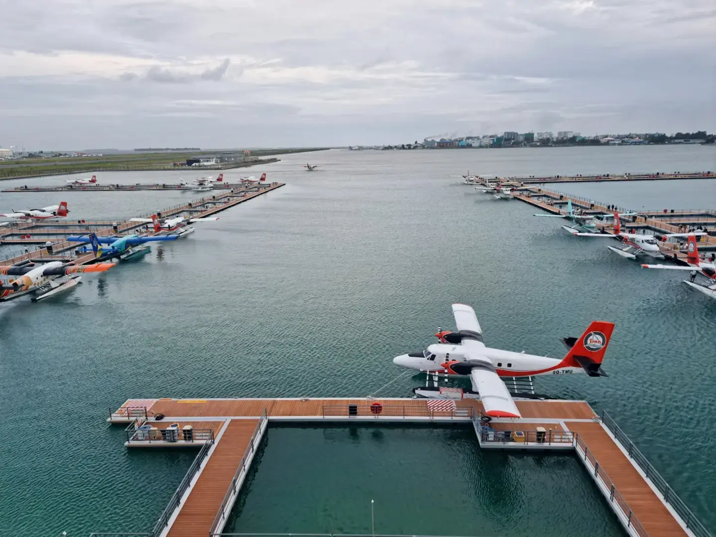 A seaplane flying over a marina filled with boats